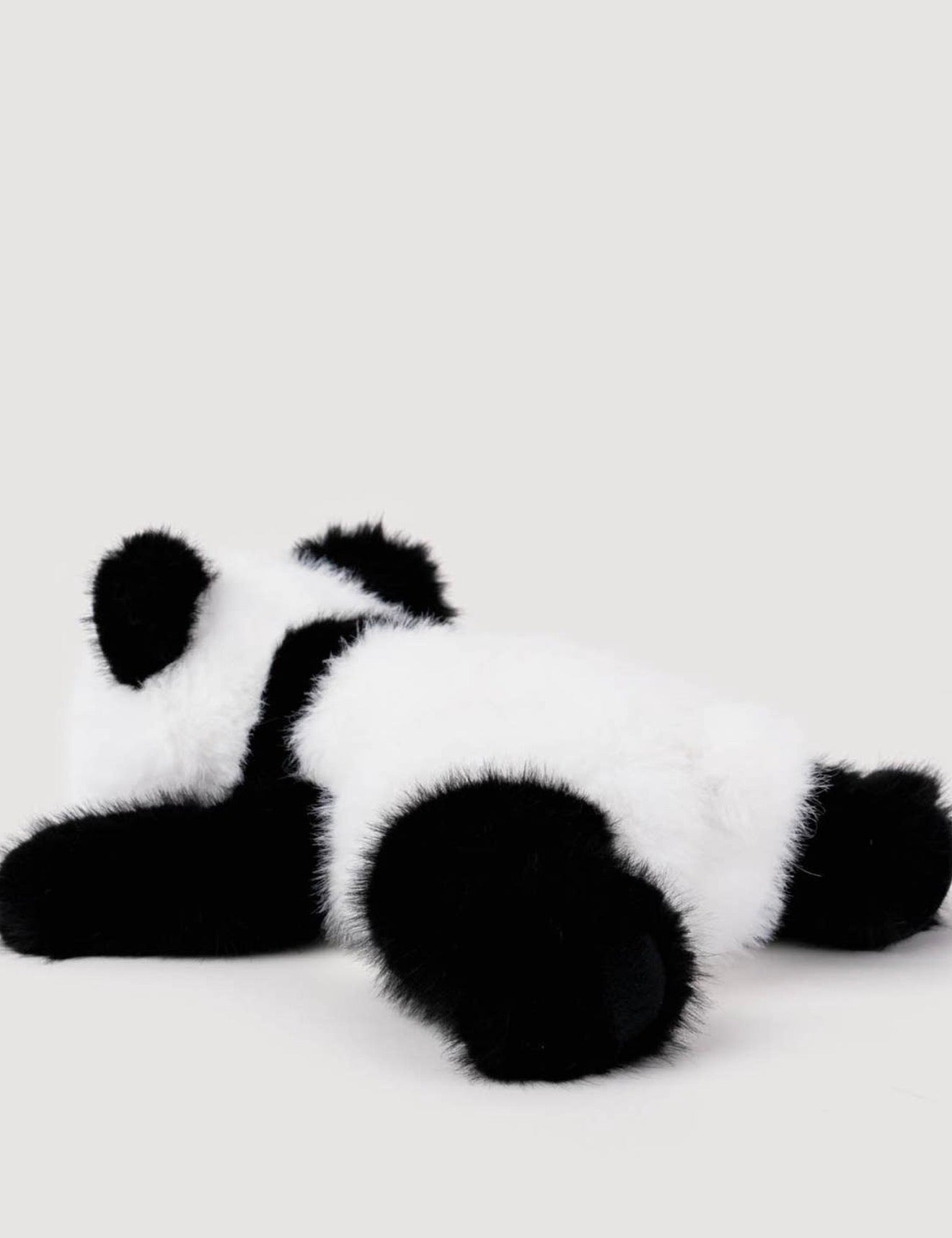 Zijaanzicht van de Pluche Panda knuffel liggend, met zwart-witte vacht en pootjes
