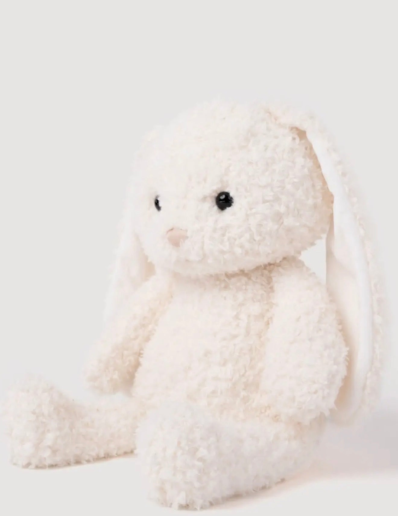 Zijaanzicht van de Retro Pals Konijn knuffel, zittend