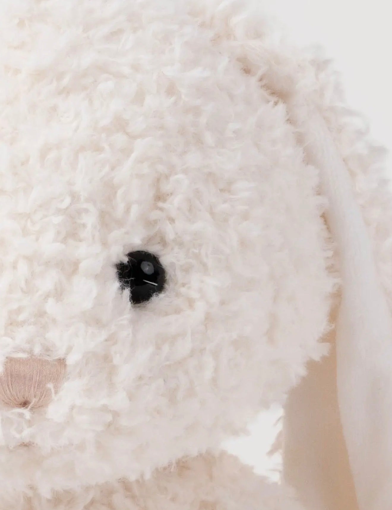 Close-up van het oog en de krullende vacht van de Retro Pals Konijn knuffel