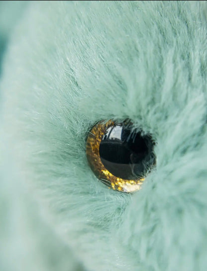 Close-up van het glanzende goudbruine oog van de Pluche Stegosaurus knuffel