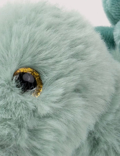Detailfoto van het goudbruine oog en de zachte saliegroene vacht van de Pluche Stegosaurus knuffel